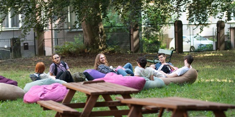 Powiększ grafikę: Zdjęcie uczniów siedzących na pufach na terenie szkoły