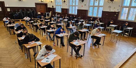 Powiększ grafikę: Zdjęcie przedstawiające uczniów piszących próbne matury w auli szkolnej