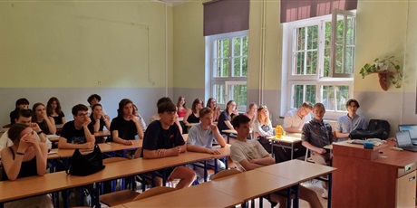 Powiększ grafikę: W sali lekcyjnej uczniowie siedzą w ławkach i słuchają wykładu