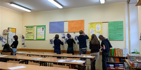 Powiększ grafikę: Zdjęcie uczniów wypisujących nowe słowa z zawieszonych na ścianie materiałów