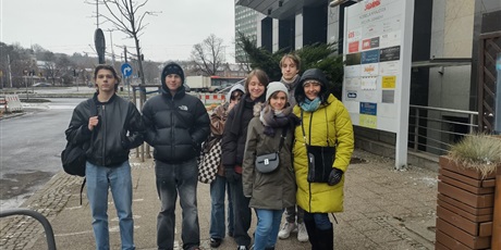 Powiększ grafikę: Grupa uczniów z wychowawczynią stoi przy budynku Solidarności