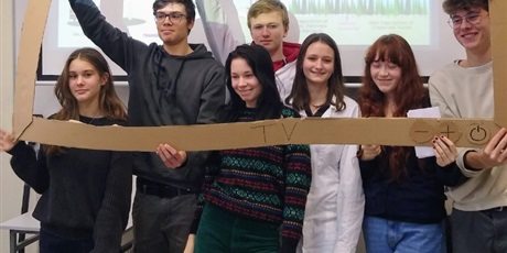 Powiększ grafikę: Uczniowie pozują do zdjęcia trzymając kartonową ramę imitującą ekan telewizora