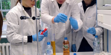 Powiększ grafikę: Trójka ucniów przy pracy w laboratorium chemicznym.